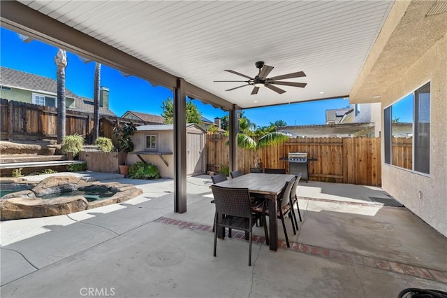 view of patio with a fenced backyard, a storage shed, an outdoor structure, outdoor dining area, and ceiling fan