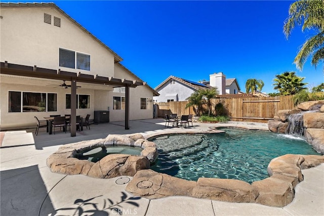 view of swimming pool featuring a pool with connected hot tub, ceiling fan, central AC, a fenced backyard, and a patio area