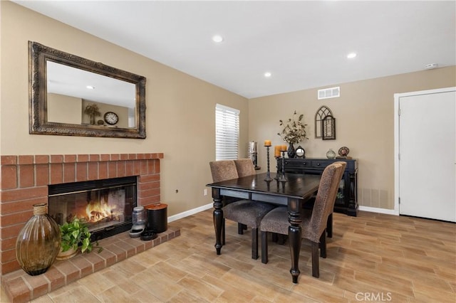 dining area with visible vents, wood finished floors, recessed lighting, a fireplace, and baseboards