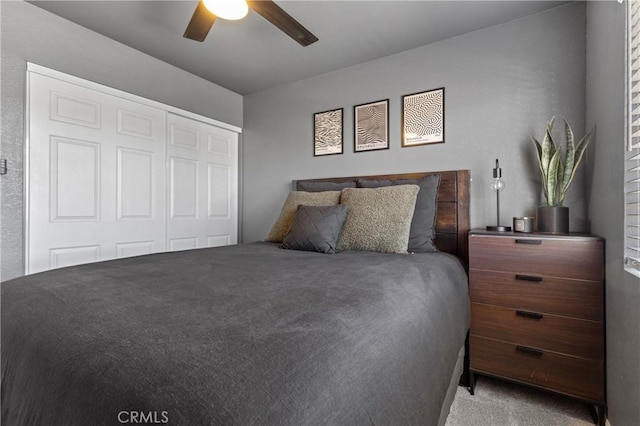 bedroom with a closet, light colored carpet, and ceiling fan