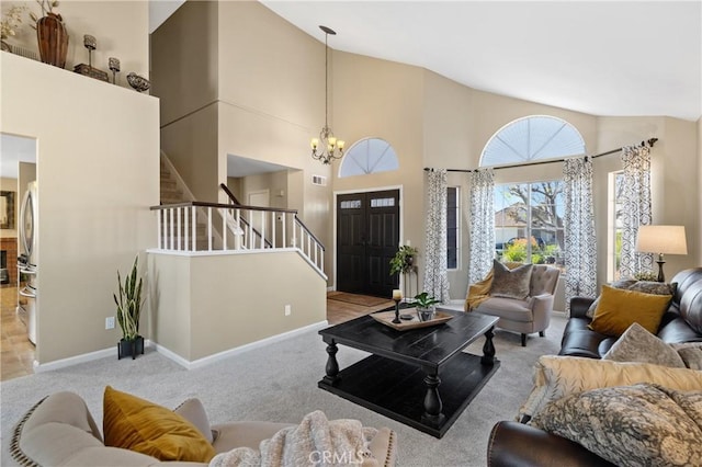 carpeted living area with visible vents, baseboards, stairs, a high ceiling, and a notable chandelier