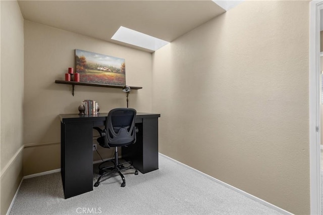 carpeted office space with baseboards and a skylight