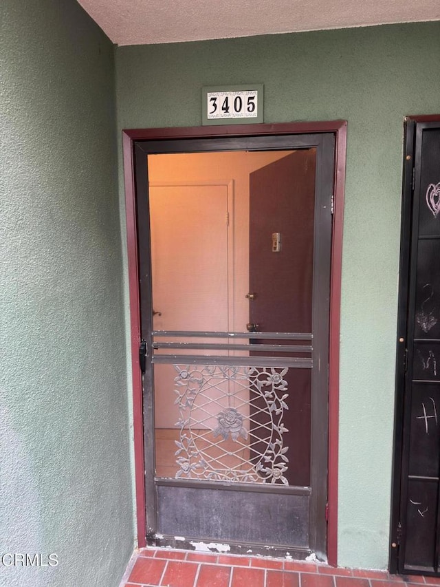 entrance to property featuring stucco siding