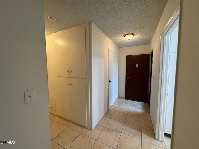 3700 Dean Dr Unit 3405, Ventura, CA 93003 - hallway with light tile patterned floors and a textured ceiling
