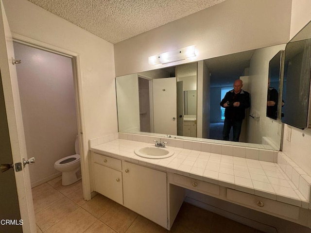3700 Dean Dr Unit 3405, Ventura, CA 93003 - bathroom featuring tile patterned floors, toilet, vanity, and a textured ceiling