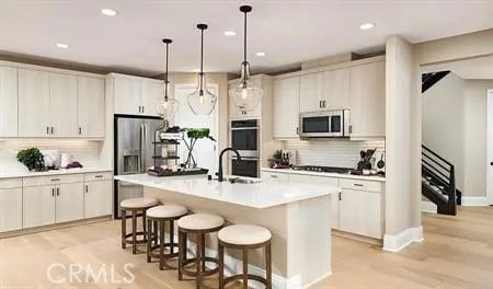 kitchen with decorative light fixtures, stainless steel appliances, a breakfast bar, and white cabinetry