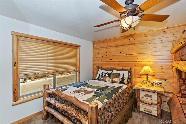 bedroom with wooden walls, carpet flooring, and a ceiling fan