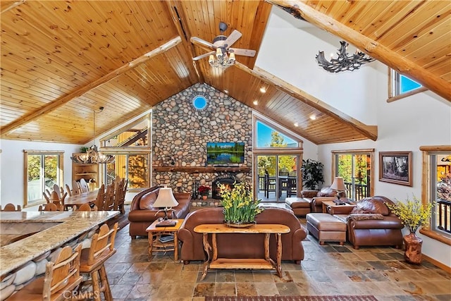 living area featuring a wealth of natural light, stone tile floors, and wooden ceiling