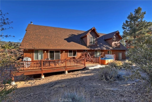 rear view of house with a deck and a shingled roof