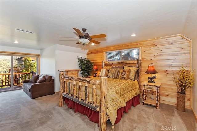 bedroom with visible vents, light carpet, access to exterior, and wood walls