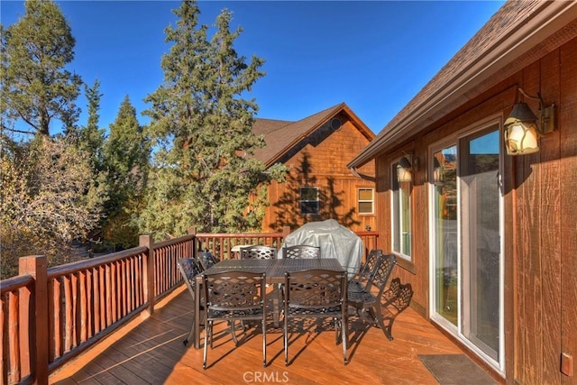 deck featuring outdoor dining area and a grill