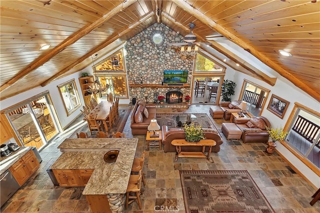 living room featuring stone tile floors, a fireplace, baseboards, wood ceiling, and vaulted ceiling