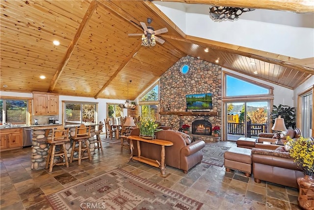 living room featuring high vaulted ceiling, stone tile flooring, a stone fireplace, wooden ceiling, and beamed ceiling