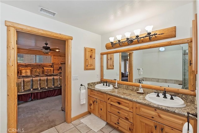 bathroom with a sink, visible vents, double vanity, and tile patterned floors