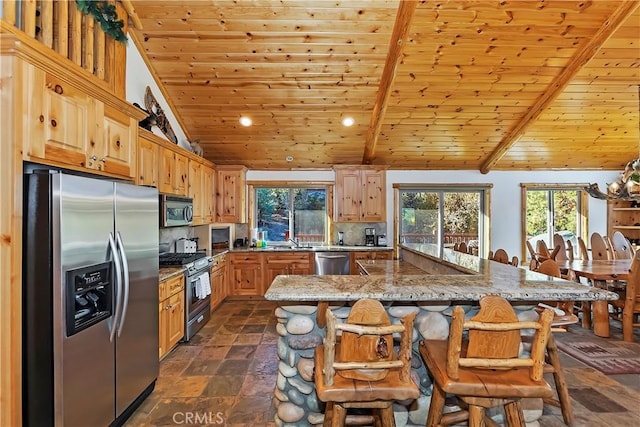 kitchen featuring a sink, stone finish floor, wood ceiling, appliances with stainless steel finishes, and backsplash