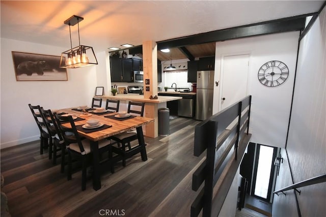 dining area featuring beamed ceiling, baseboards, and dark wood-style flooring