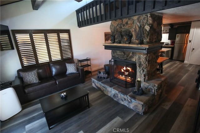 living room with a stone fireplace, baseboards, and wood finished floors