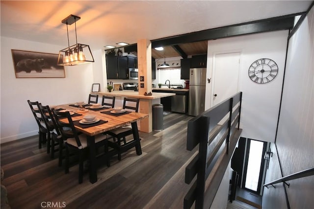 dining area with dark wood-style floors, beamed ceiling, and baseboards