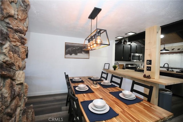 dining area featuring baseboards and dark wood-style flooring