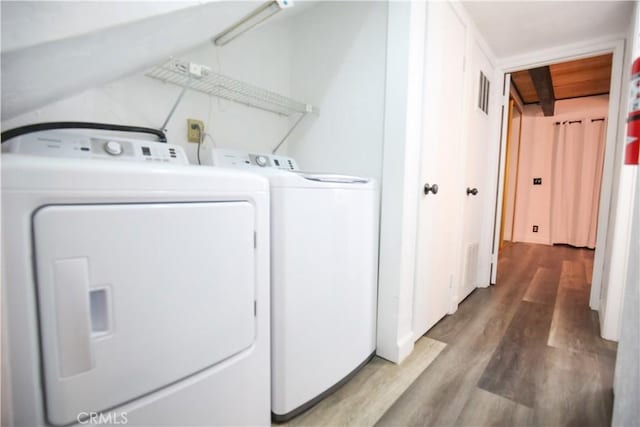 washroom featuring visible vents, separate washer and dryer, wood finished floors, and laundry area