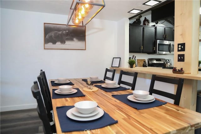 dining space with baseboards and dark wood-type flooring