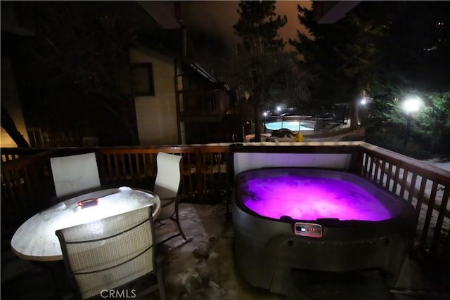 patio at twilight featuring a pool, a hot tub, and outdoor dining area