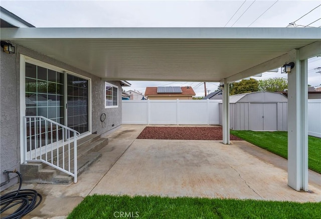 view of patio featuring entry steps, a storage unit, an outdoor structure, and fence