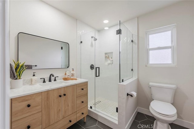 bathroom with a shower stall, baseboards, toilet, tile patterned floors, and vanity