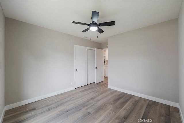 unfurnished bedroom with visible vents, ceiling fan, baseboards, light wood-type flooring, and a closet