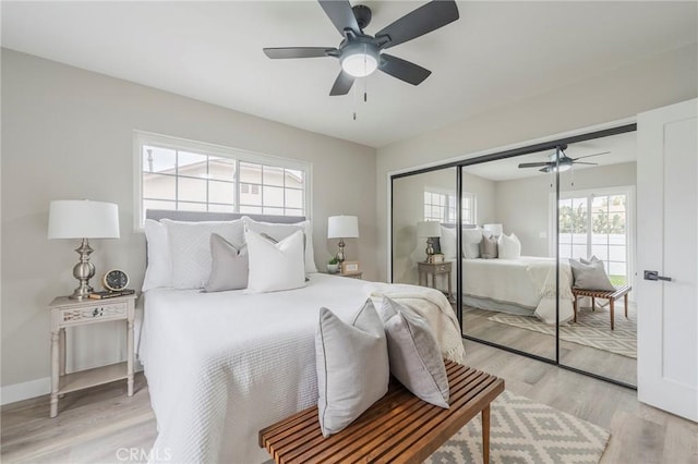 bedroom featuring a ceiling fan, baseboards, a closet, and light wood-type flooring