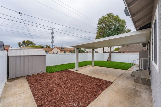 view of yard featuring a patio area, a shed, an outbuilding, and a fenced backyard