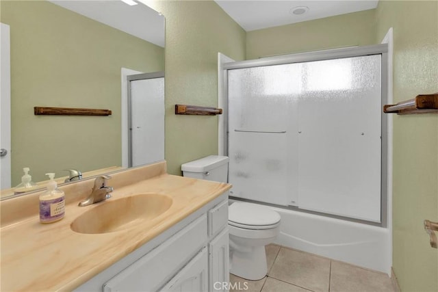 bathroom featuring vanity, tile patterned floors, toilet, and combined bath / shower with glass door