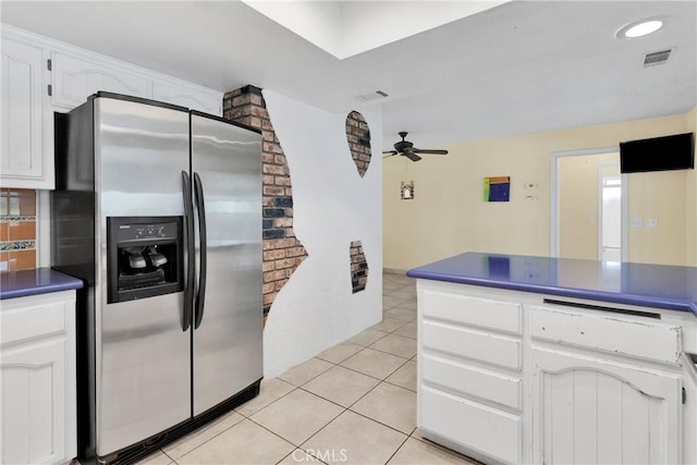 kitchen featuring white cabinetry, dark countertops, visible vents, and stainless steel fridge