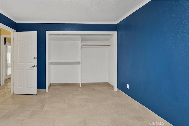 unfurnished bedroom featuring a closet, a textured ceiling, and baseboards