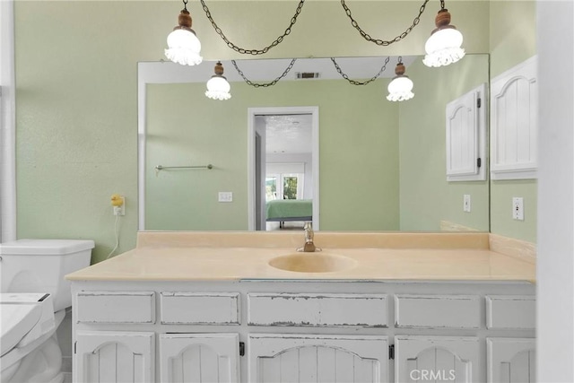 bathroom with vanity, toilet, and visible vents