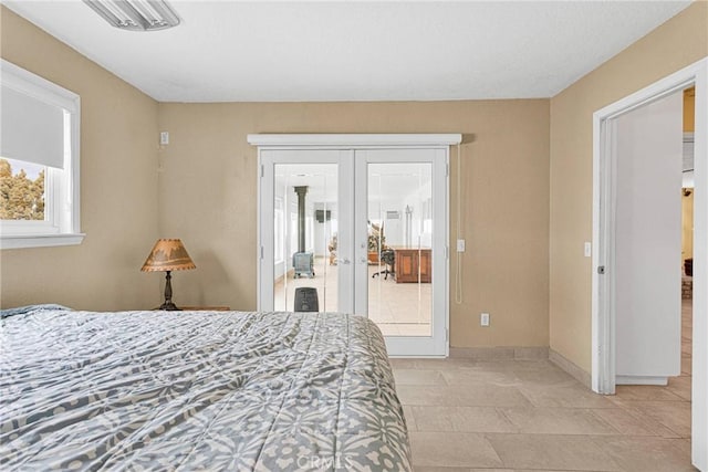 bedroom with french doors, baseboards, and access to outside