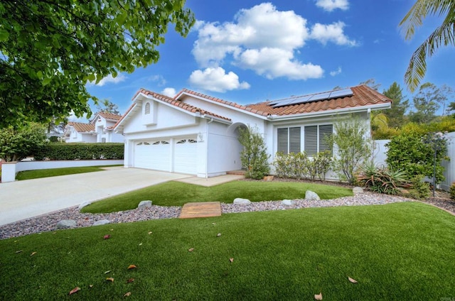 mediterranean / spanish-style home featuring driveway, a tile roof, a front yard, an attached garage, and solar panels