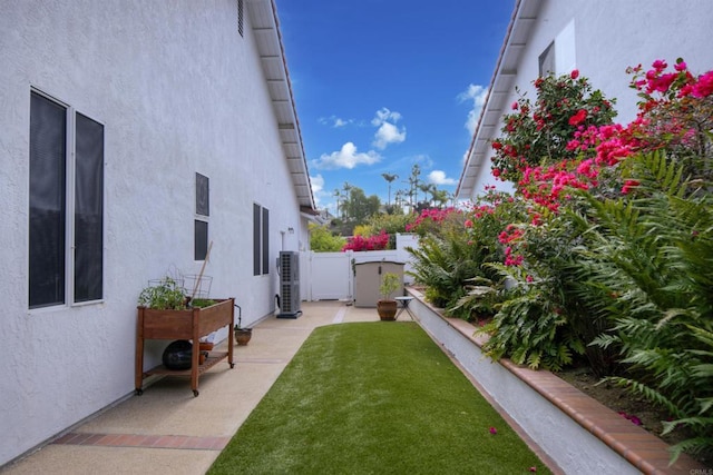 view of yard featuring a patio, central AC unit, and fence