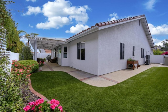 rear view of house featuring stucco siding, a pergola, a fenced backyard, a yard, and a patio area