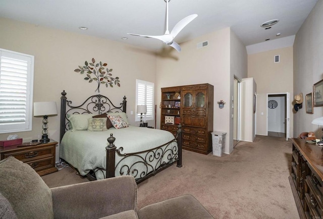 bedroom with visible vents, carpet flooring, a ceiling fan, and a towering ceiling