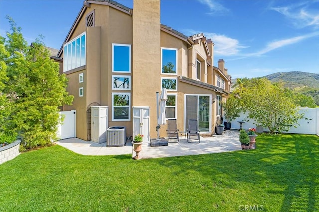 back of property featuring a yard, fence, and stucco siding