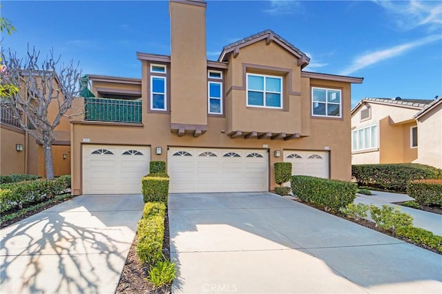 view of front of property featuring stucco siding, driveway, and a garage