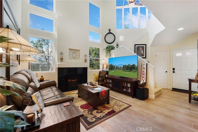 living area featuring recessed lighting, stairway, wood finished floors, and a tile fireplace