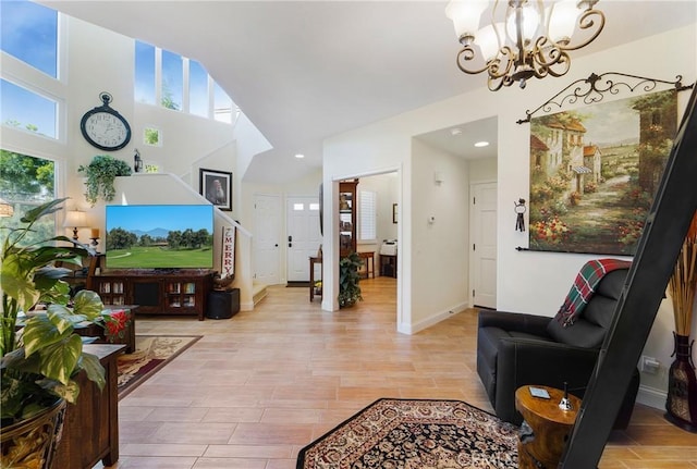 living room with wood finish floors, baseboards, and an inviting chandelier