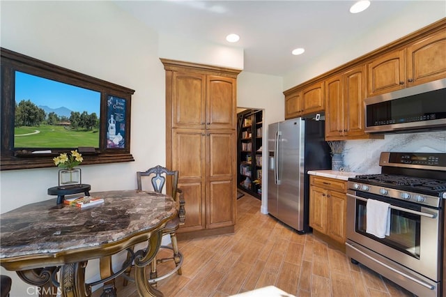 kitchen featuring light wood finished floors, recessed lighting, decorative backsplash, appliances with stainless steel finishes, and brown cabinets