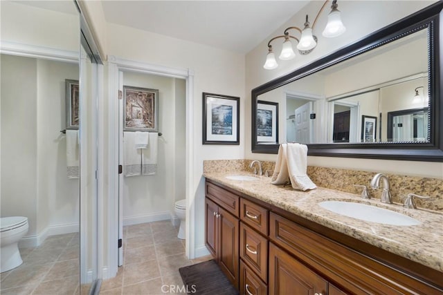 bathroom featuring a sink, toilet, and tile patterned floors