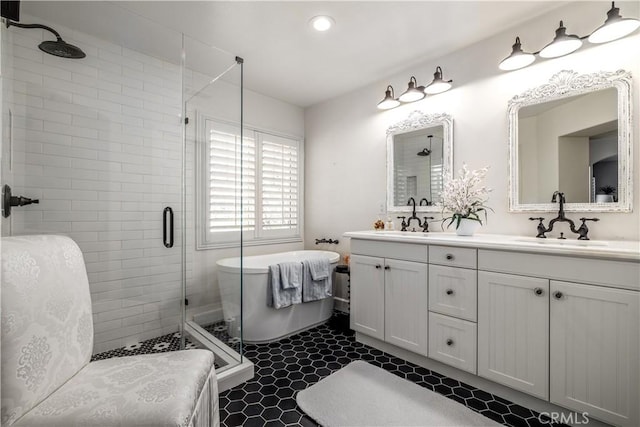 full bathroom with a freestanding bath, a shower stall, double vanity, and a sink