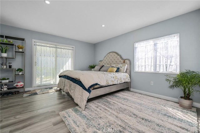 bedroom with recessed lighting, wood finished floors, and baseboards