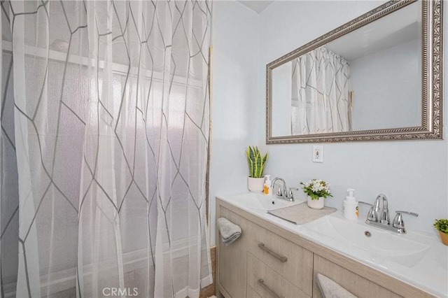 full bath with double vanity, a shower with shower curtain, and a sink