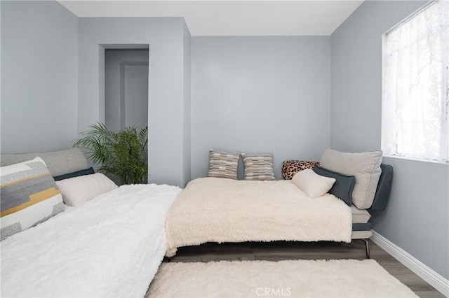 bedroom featuring baseboards and wood finished floors